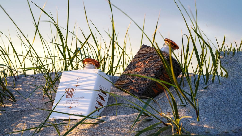 2 handgefertigte Ginflaschen mit besonderem Geschmack liegen im Sand auf norddeutscher Düne